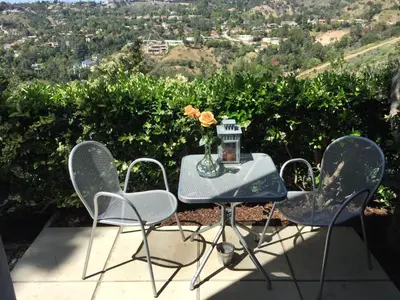 a table with chairs and a vase with flowers on it at Silver Box Beverly Hills in Los Angeles
