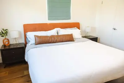 a bedroom with a large white bed with two night stands at Mid Century Modern - Walk to Dodger Stadium, DTLA in Los Angeles