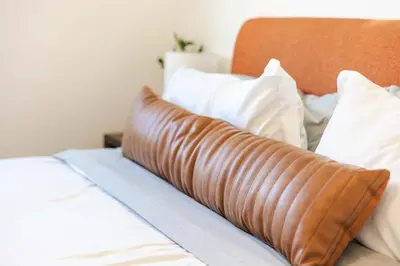 a pillow on a bed with white pillows at Mid Century Modern - Walk to Dodger Stadium, DTLA in Los Angeles
