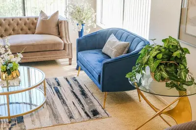 a living room with a blue couch and a glass table at Peaceful Private Retreat In The Heart Of Town in Redlands