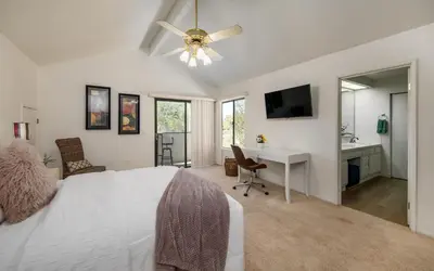 a bedroom with a bed with a ceiling fan and a desk at Peaceful Private Retreat In The Heart Of Town in Redlands