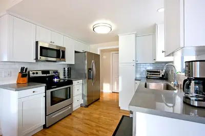 a kitchen with white cabinets and stainless steel appliances at Beautiful Views - Sand Section of Manhattan Beach 2 Bed/2 Bath in Manhattan Beach