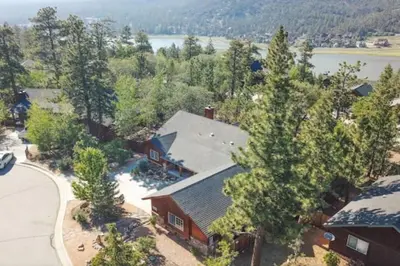 an aerial view of a house with trees and a lake at CUSTOM SINGLE STORY CABIN WITH JACUZZI POOL TABLE & BIG GAME ROOM WITH ARCADE games in Big Bear Lake