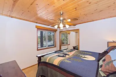 a bedroom with a bed and a ceiling fan at CUSTOM SINGLE STORY CABIN WITH JACUZZI POOL TABLE & BIG GAME ROOM WITH ARCADE games in Big Bear Lake