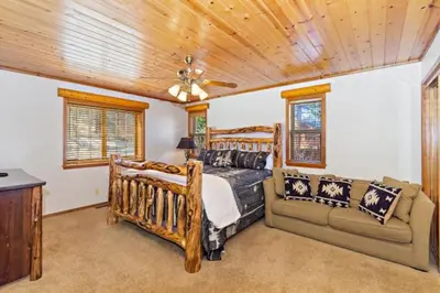 a bedroom with two beds and a couch at CUSTOM SINGLE STORY CABIN WITH JACUZZI POOL TABLE & BIG GAME ROOM WITH ARCADE games in Big Bear Lake