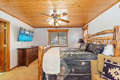a bedroom with a bed and a ceiling fan at CUSTOM SINGLE STORY CABIN WITH JACUZZI POOL TABLE & BIG GAME ROOM WITH ARCADE games in Big Bear Lake