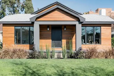 a wooden house with a lawn in front of it at Modern Bungalow with a Pool in Larchmont Village in Los Angeles