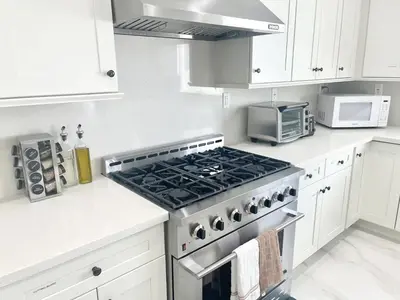 a white kitchen with a stove and a microwave at Huge Family Home Near Disneyland & SoCal Beaches in Midway City