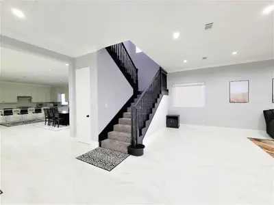 a white living room with a staircase in a house at Huge Family Home Near Disneyland & SoCal Beaches in Midway City