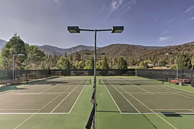 a tennis court with mountains in the background at Pine Mountain Club Home with Beautiful View! in Frazier Park