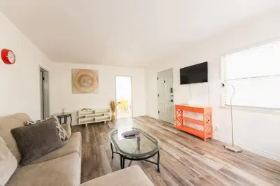 a living room with a couch and a glass table at Spring Charmer In The Heart Of The City in Los Angeles