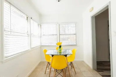 a dining room with a table and yellow chairs at Spring Charmer In The Heart Of The City in Los Angeles