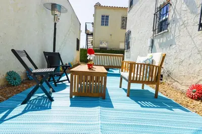 a patio with chairs and a table on a blue rug at Spring Charmer In The Heart Of The City in Los Angeles