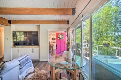 a living room with a glass table and a window at Chic Lake House with Furnished Deck and Hot Tub! in Lake Arrowhead