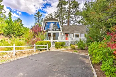 a white house with a white fence and a driveway at Château Forêt in Big Bear with Hiking Trail Access in Big Bear City