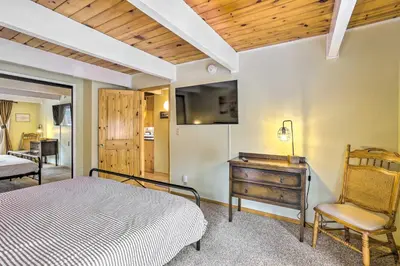 a bedroom with a bed and a desk and a chair at Château Forêt in Big Bear with Hiking Trail Access in Big Bear City