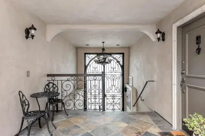 a wrought iron door in a hallway with a table and chairs at Luxury 2-Bedroom Condo in Studio City in Los Angeles