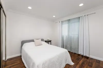 a white bedroom with a bed and a window at Luxury 2-Bedroom Condo in Studio City in Los Angeles