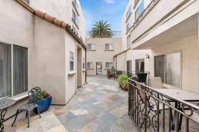 a balcony with tables and chairs on a building at Luxury 2-Bedroom Condo in Studio City in Los Angeles