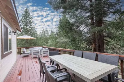 a wooden deck with a wooden table and chairs at Hillside Hideaway - game rm - master spa - Luxury in Lake Arrowhead