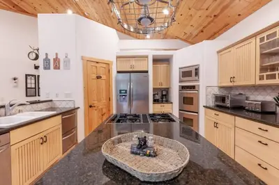 a kitchen with wooden cabinets and a counter top at Hillside Hideaway - game rm - master spa - Luxury in Lake Arrowhead