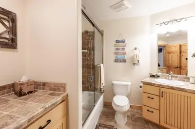 a bathroom with a toilet and a shower and a sink at Hillside Hideaway - game rm - master spa - Luxury in Lake Arrowhead