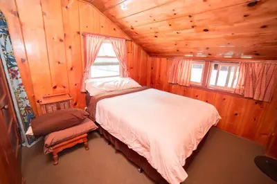 a bedroom with a bed in a wooden cabin at ITH Big Bear Lake Hostel & Lodge in Big Bear Lake