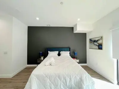 a bedroom with a large bed with white sheets at 4BR Townhouse in KoreaTown in Los Angeles
