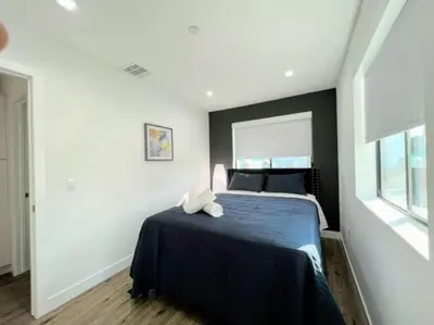 a bedroom with a bed with a blue blanket and a window at 4BR Townhouse in KoreaTown in Los Angeles
