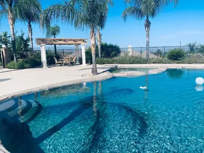 a swimming pool with a gazebo and palm trees at High End Triplex with Pool in Riverside