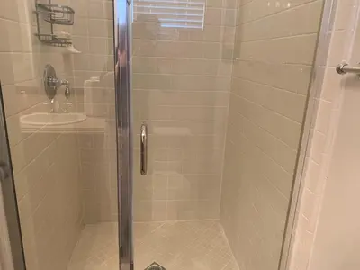 a shower with a glass door next to a sink at High End Triplex with Pool in Riverside