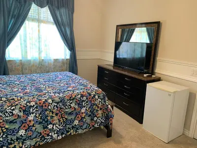 a bedroom with a bed and a dresser with a tv at High End Triplex with Pool in Riverside