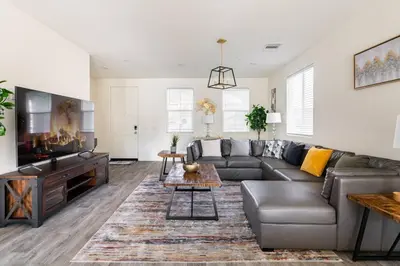 a living room with a couch and a tv at Spacious Modern Home in Sierra Lakes Fontana in Fontana