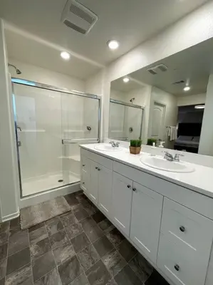 a bathroom with two sinks and a shower at Spacious Modern Home in Sierra Lakes Fontana in Fontana