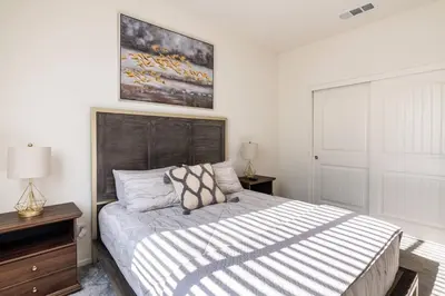 a bedroom with a large bed with a wooden headboard at Spacious Modern Home in Sierra Lakes Fontana in Fontana