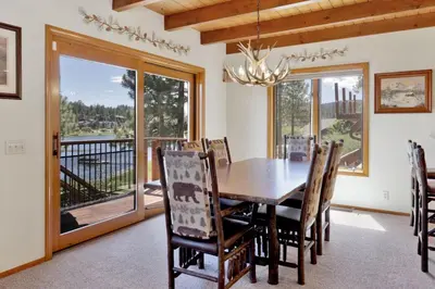 a dining room with a table and chairs and a balcony at Cove Lakefront Chalet #2098 by Big Bear Vacations in Big Bear Lake