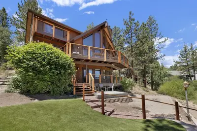 a large wooden house with a porch and balcony at Cove Lakefront Chalet #2098 by Big Bear Vacations in Big Bear Lake