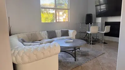 a living room with a white couch and a table at LA Dream Gem - Beautiful Home with Spa in Los Angeles