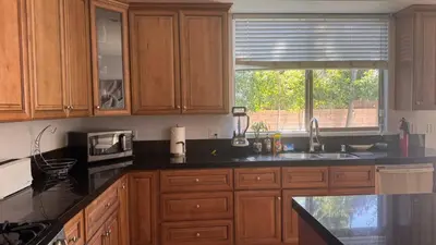 a kitchen with wooden cabinets and a sink and a window at LA Dream Gem - Beautiful Home with Spa in Los Angeles