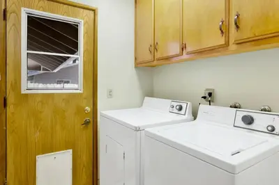a laundry room with a washer and dryer and a door at Crestwood Summit #2119 by Big Bear Vacations in Big Bear Lake