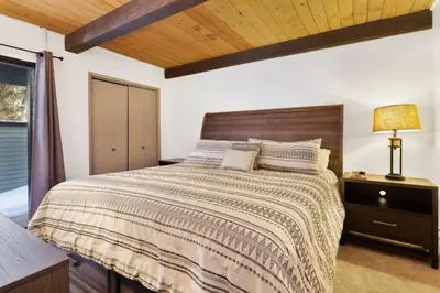 a bedroom with a large bed with a wooden ceiling at Switzerland Slopes #2125 by Big Bear Vacations in Big Bear Lake