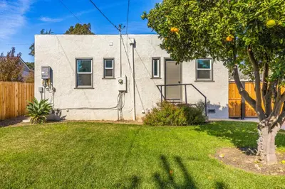 a house with an orange tree in a yard at Mid-Town Escape in Ventura
