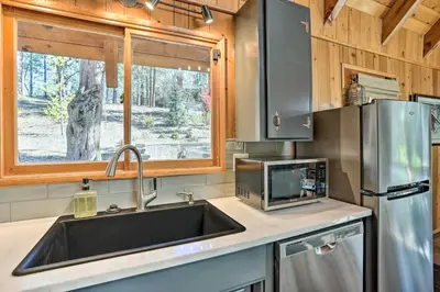 a kitchen with a sink and a microwave at Modern Cabin with Hot Tub Ski and Hike Big Bear! in Big Bear Lake
