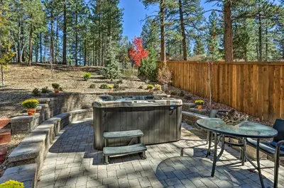 a patio with a fountain and a table and a fence at Modern Cabin with Hot Tub Ski and Hike Big Bear! in Big Bear Lake