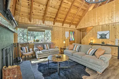 a living room with a couch and a table at Modern Cabin with Hot Tub Ski and Hike Big Bear! in Big Bear Lake
