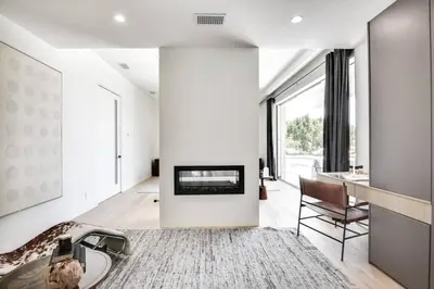 a living room with a fireplace and a table at Vista Modern in Los Angeles