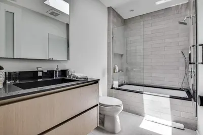 a white bathroom with a toilet and a sink at Vista Modern in Los Angeles
