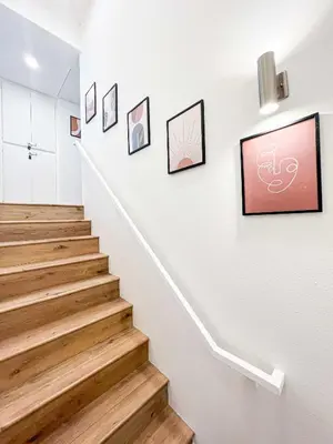 a hallway with stairs with paintings on the wall at Comfy 2-bedroom home in Hollywood in Los Angeles