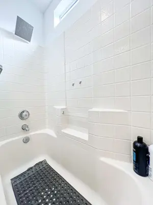 a white bath tub with a black mat in a bathroom at Comfy 2-bedroom home in Hollywood in Los Angeles