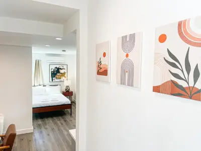 a bedroom with a bed and paintings on the wall at Cozy Habitat in Los Angeles
